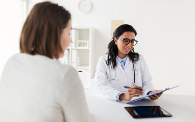 doctor with clipboard and woman patient at clinic