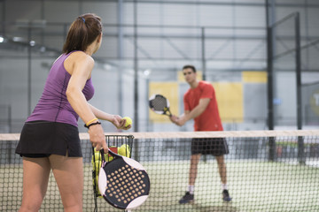 Paddle tennis couple training in indoor court