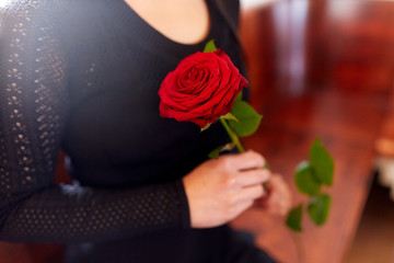 close up of woman with roses at funeral in church