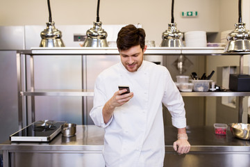chef cook with smartphone at restaurant kitchen