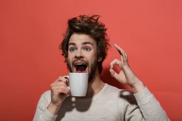 ok gesture of surprised man with cup of coffee
