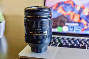 Fototapeta na wymiar Close-Up View of Professional Camera Lens on Laptop