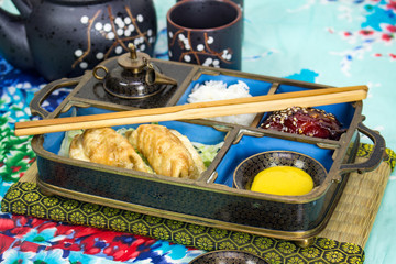 Chopsticks, rice, pork, pot stickers and hot mustard 