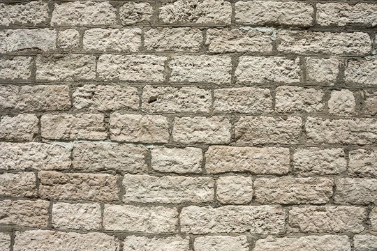 The masonry of an ancient stone wall eroded. Close-up