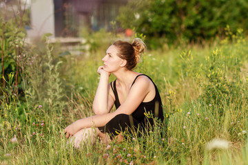 Naklejka na ściany i meble Young woman sitting on grass