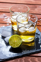 glass of whiskey on wooden background