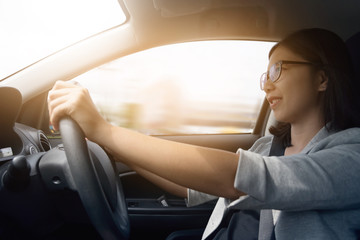 Asian woman driving a car.