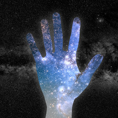conceptual image of close up hand and universe