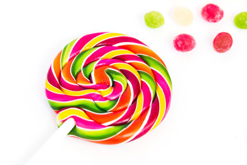 Fototapeta na wymiar Rainbow sweet sweet bright round lollipop and many colorful little lollipops on a white background