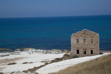 Fototapeta na wymiar Old mediterranean stone house on a chalky coast