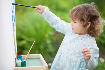 Closeup portret of a little talented painter, toddler girl