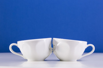 Two white cups on a blue background. I love uou.