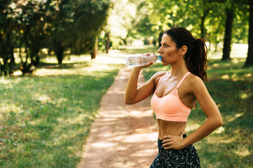 Ftness athlete woman drinking water after work out exercising outdoor.