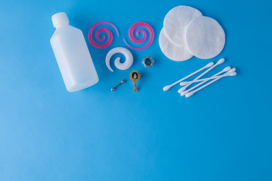 Accessories for piercing on blue background. Top view