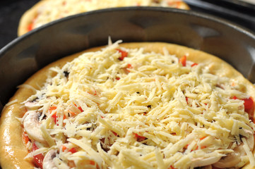 Homemade pizza, process of cooking. Layer of grated cheese