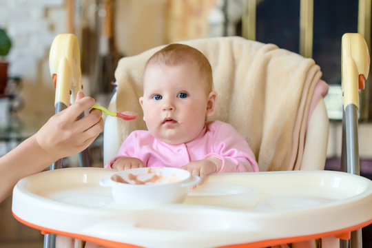 A cheerful happy child eats porridge.