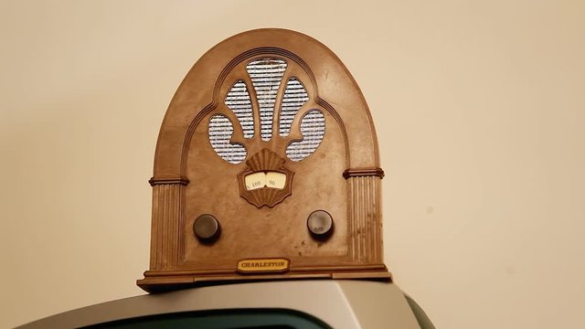 An old vintage radio standing on a tv. Interior shot, slow zoom in.
