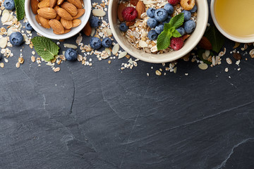 Healthy cereal breakfast with seasonal berries, almonds, farm milk and honey