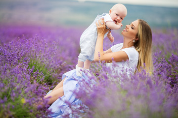 Happy mother and her little son having fun in a lavender field