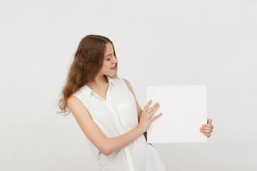 Young woman holding blank poster.Smiling woman sign board holding. Girl showing banner with copy...