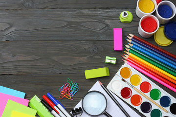 school and office supplies. school background. colored pencils, pen, pains, paper for  school and student education on dark wooden background. top view with copy space