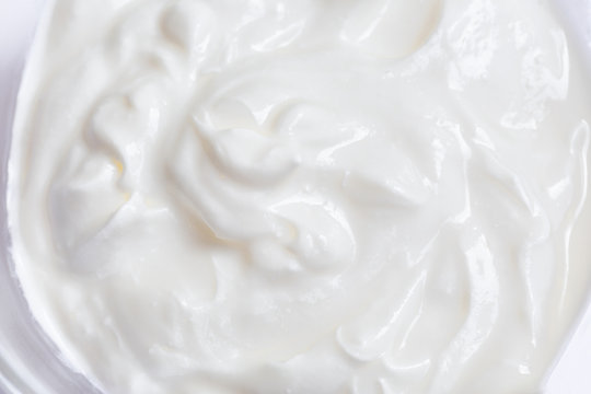 White whipped or sour cream on white background, close up, macro