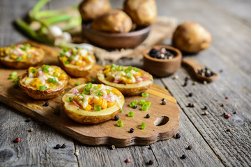 Obraz na płótnie Canvas Potato boats filled with corn, ham, cheese and green onion