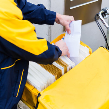 Postbote sortiert Briefe nach Empf&auml;nger Adressen