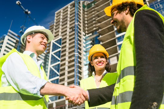Architects and foreman in meeting at construction site
