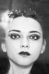 beautiful woman soaks in the warm water with just her face visible above the water and looking at camera, closeup portrait, monochrome