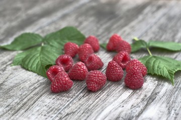 Ripe raspberries on a wooden background.