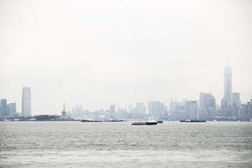 Naklejka premium Manhattan skyline and statue of liberty seen from the ocean, New York