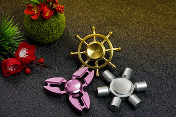 Hand spinners or fidgeting spinners. Various types and shapes of spinners put on the black stone...