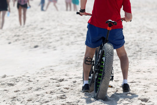 A man on a fat wheel bike on the beach