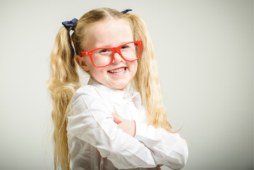 Schoolgirl in glasses reaching toward the school.