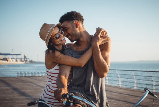 Portrait of a mixed race couple on tandem bicycle outdoors near the sea