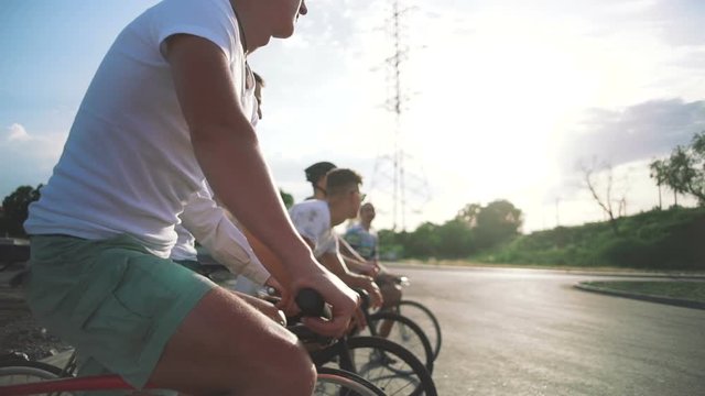 Group of cyclists with fixed gear bikes on the road, steadycome shot, slow motion