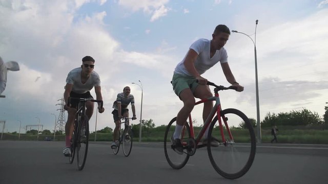 Group of cyclists riding fixed gear bikes on the road, steadycome shot