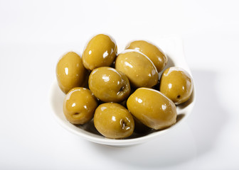 Whole green olives in white bowl