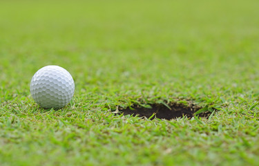 golf ball on lip of cup