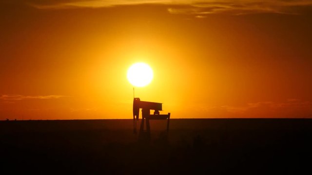 Pump jack oil rig at sunset