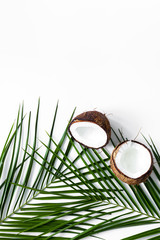 Obraz na płótnie Canvas Appetizing cocount and palm branch on white background top view copyspace