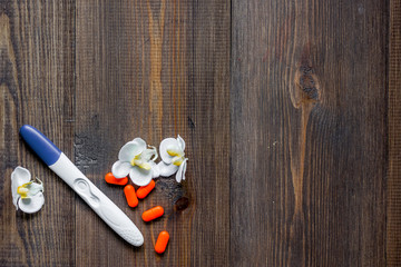 Pregnancy test and pills on wooden background top view copyspace