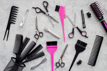 Combs and hairdresser tools on grey table background top view