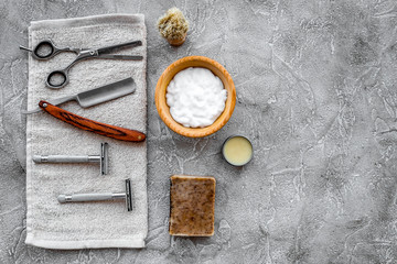 Accessories for shaving. Shaving brush, razor, foam, sciccors on grey stone table background top view copyspace