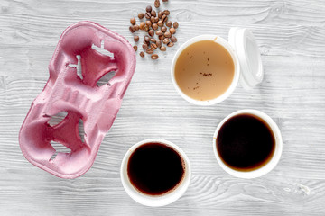 Coffee to go. Coffee cups with cover and coffee beans on wooden table backound top view