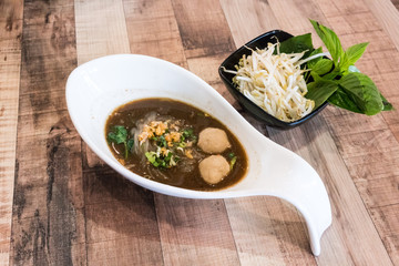 Beef noodle soup with meat ball served with bean sprout and holy basil vegetable