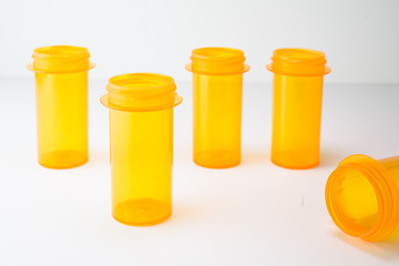 5 Rx Vials staggered on white, could be used to represent medical care or addiction