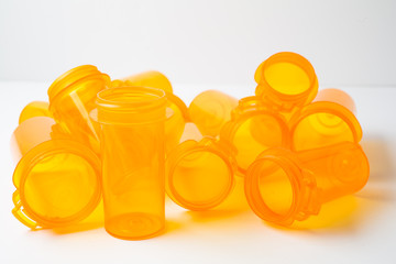 A dozen Prescription (Rx) vials piled on a white counter, conceptualizing either healthcare or addiction/substance abuse