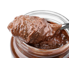 Creamy peanut butter in spoon and jar on white background, closeup